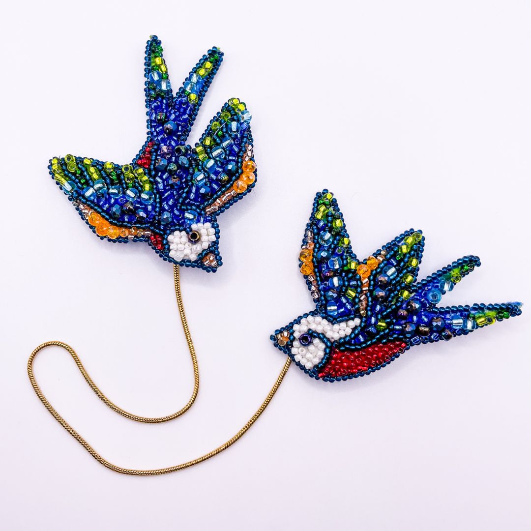 Jaskółki broszki połączone łańcuszkiem