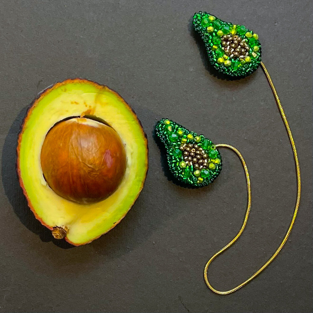 Awokado broszki połączone łańcuszkiem.